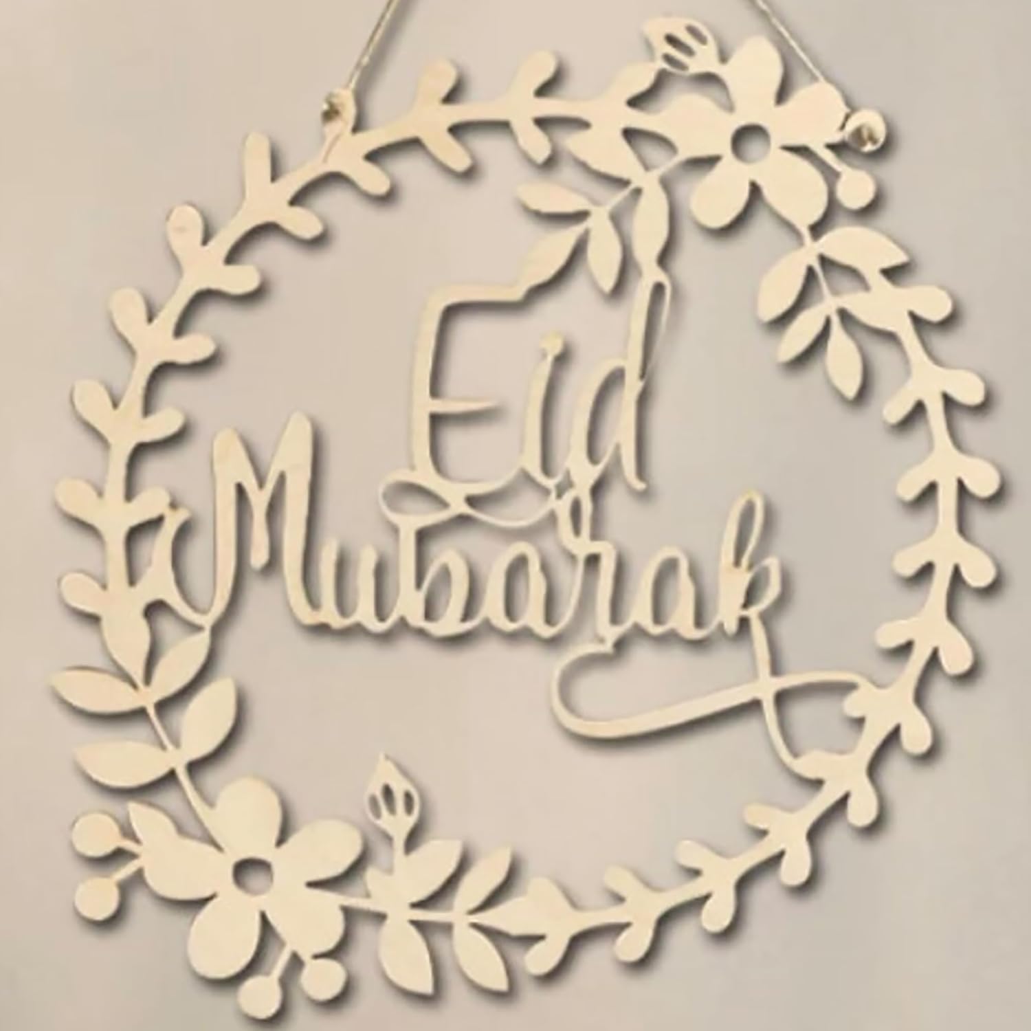 Decorative wreath with 'Eid Mubarak' text on a beige background