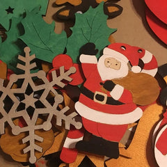 Collection of Christmas-themed cutout decorations including a Santa Claus figure, snowflake, and holly leaves.