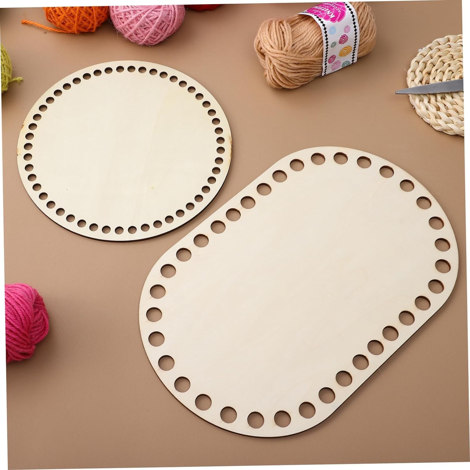 Two wooden lace knitting boards with yarn on a brown surface