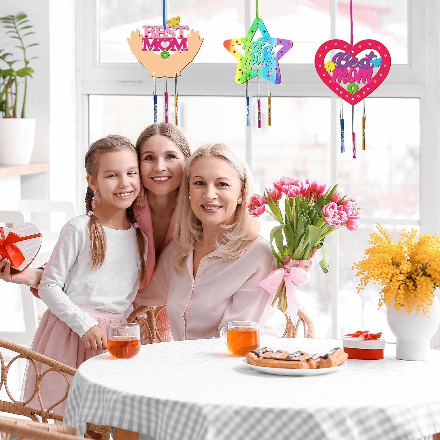Family celebrating Mother's Day with decorative signs and flowers.