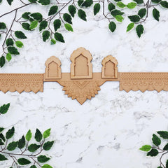 Decorative wooden panel with intricate carvings on a white marble background with green leaves.