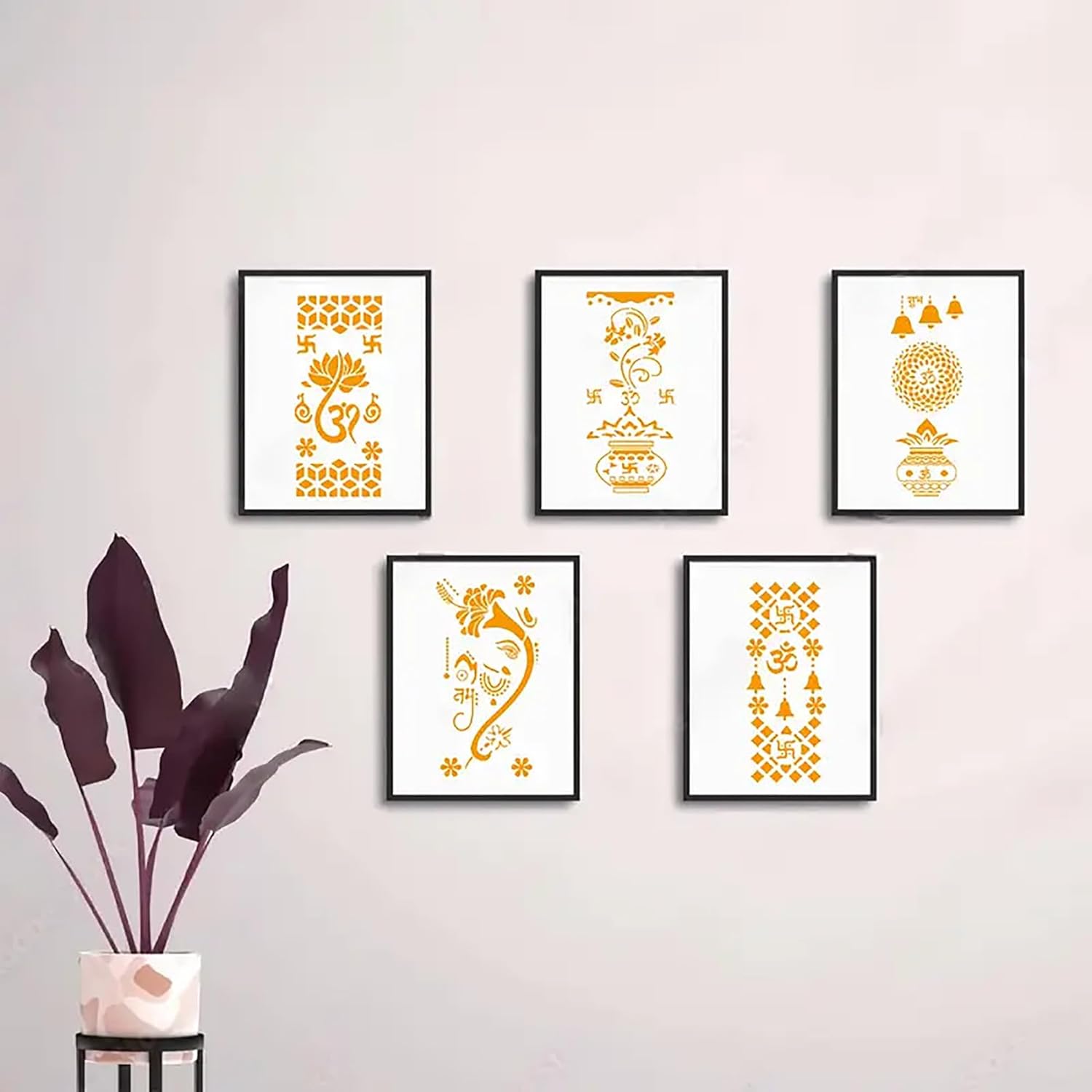 Five framed decorative prints with gold patterns on a light pink wall, accompanied by a plant.