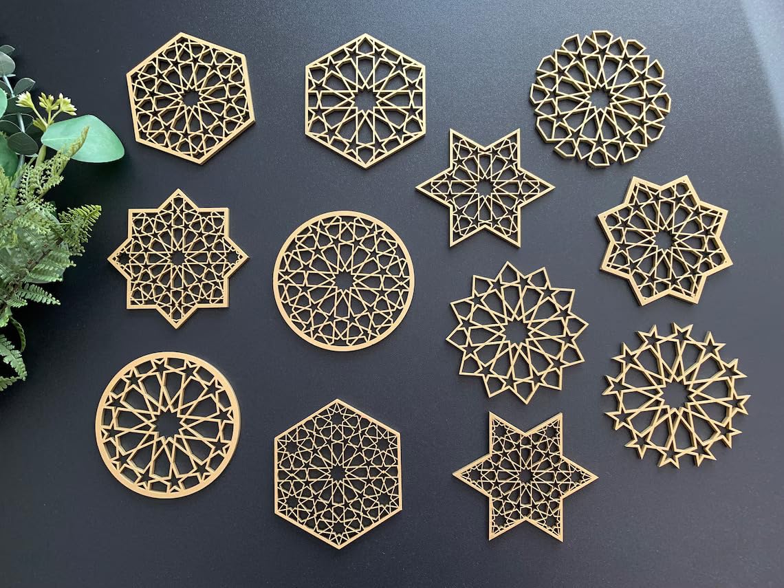 Gold geometric coasters on a dark surface with greenery