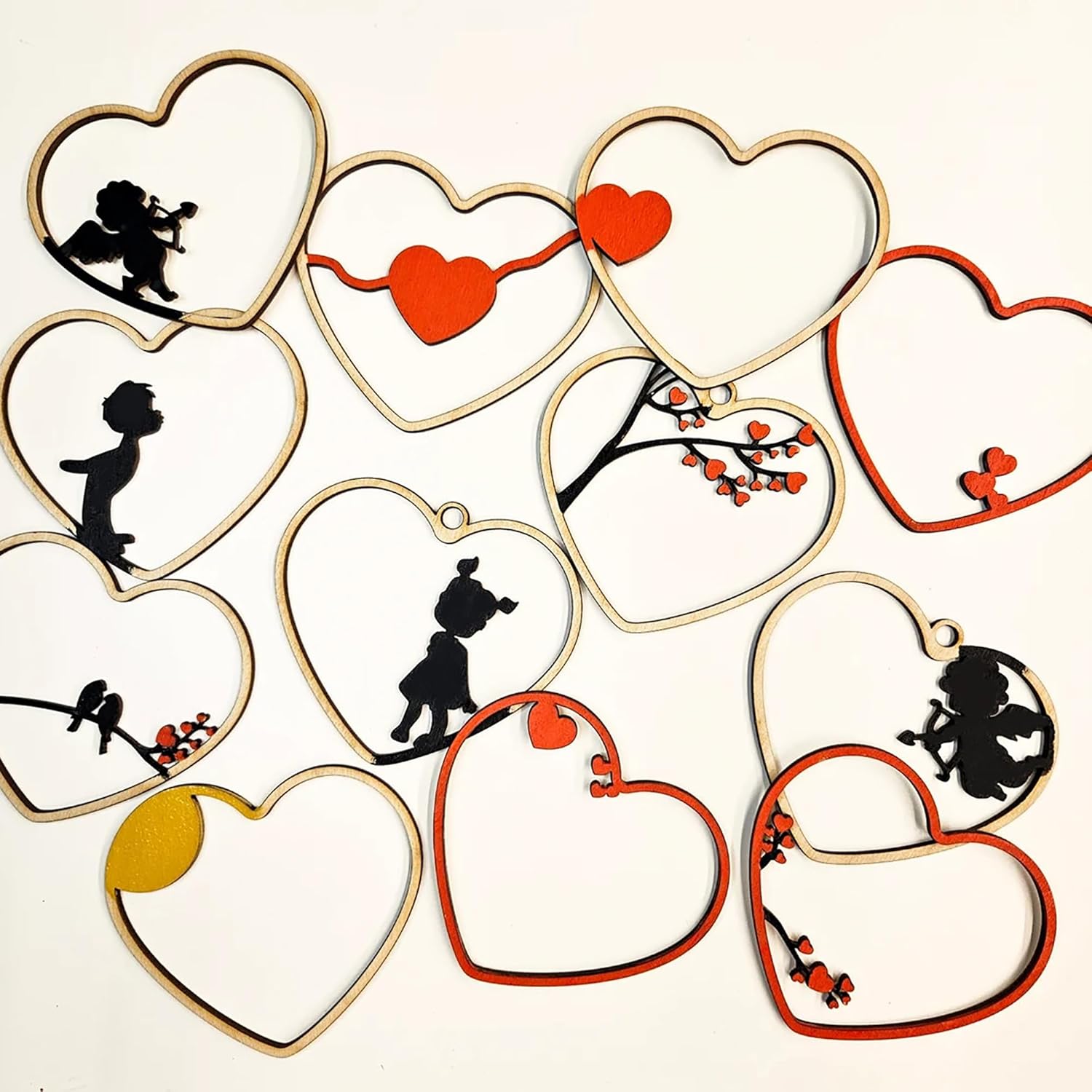 Heart-shaped cutouts with various designs including silhouettes and red hearts on a white background.