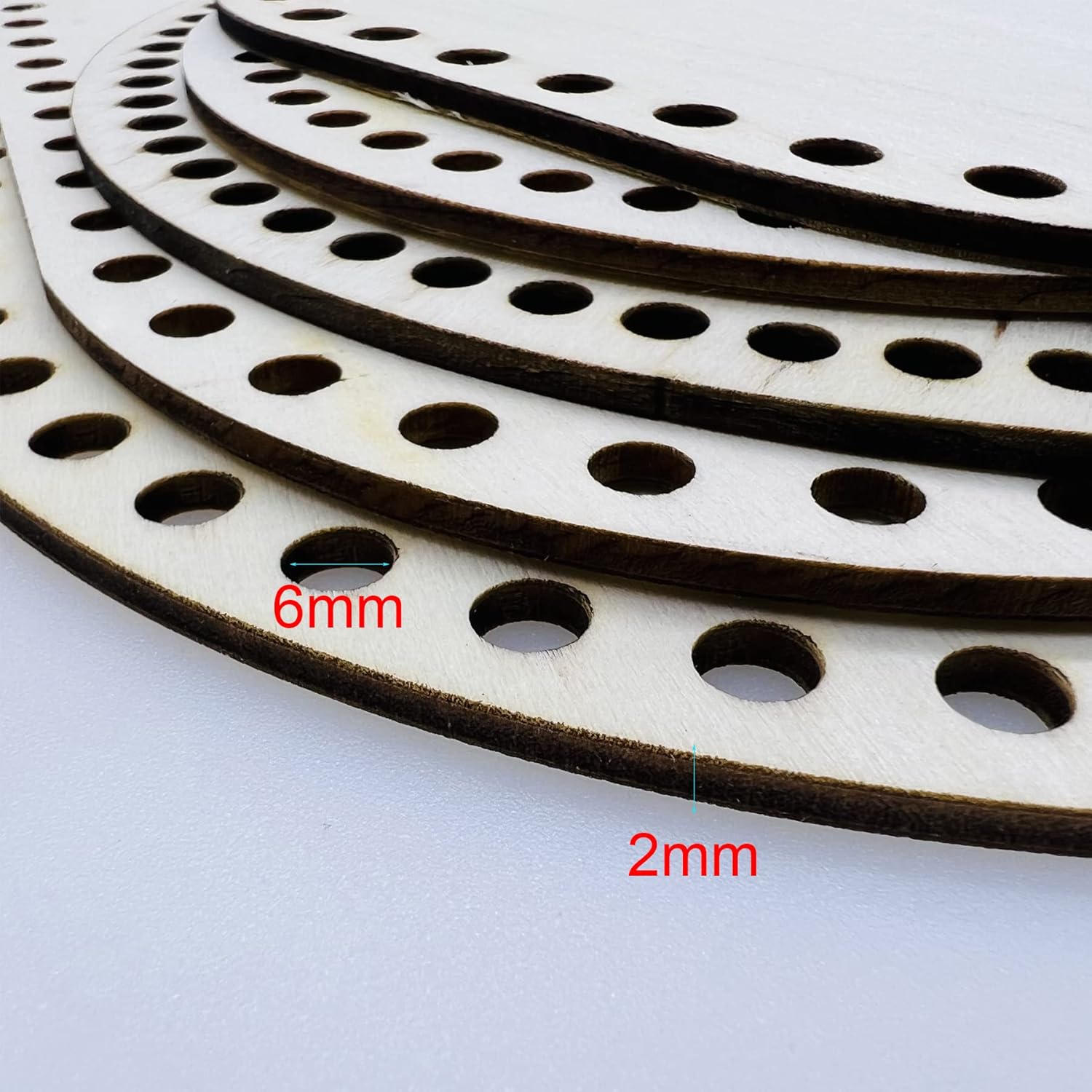 Stack of circular metal brake pads with hole sizes labeled on a white background