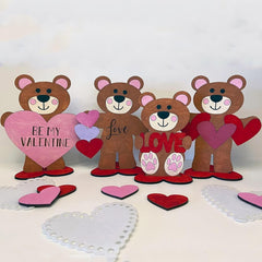 Four teddy bear cutouts with Valentine's Day messages and hearts on a white background
