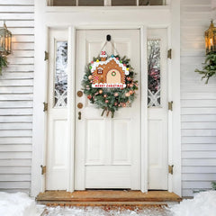 Decorative Christmas wreath with a gingerbread house on a white door of a house.