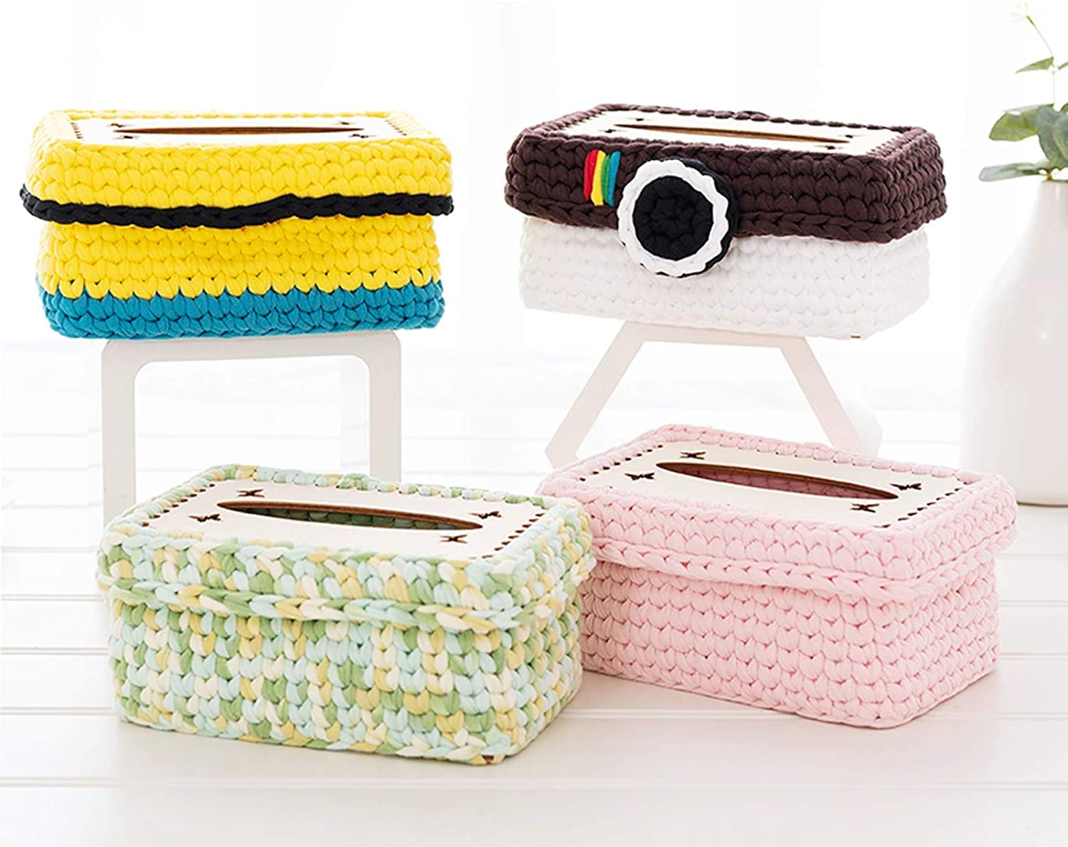 Set of colorful woven tissue boxes on a white surface