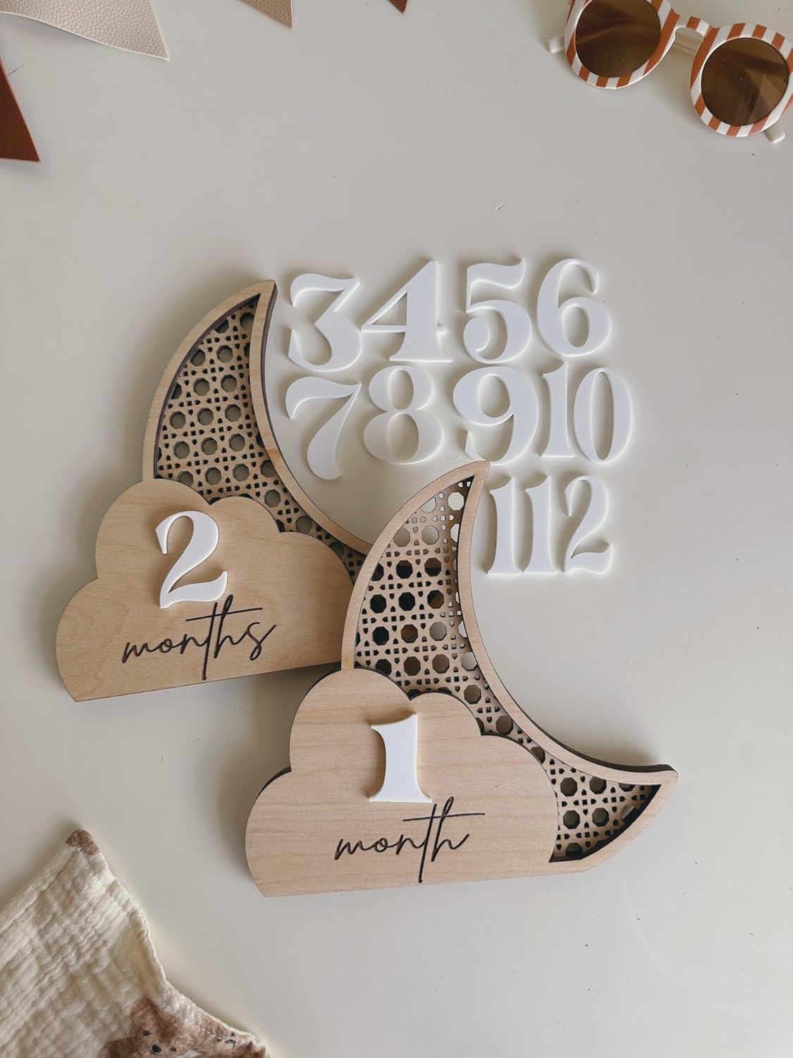 Wooden baby milestone markers with numbers and months on a light background