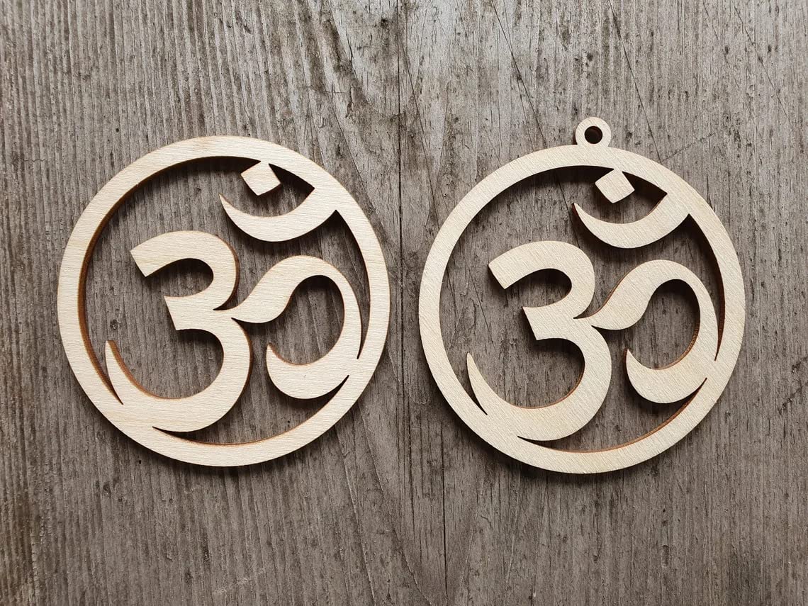 Two wooden OM symbol pendants on a wooden surface
