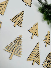 Wooden Christmas tree decorations on a white background with greenery.