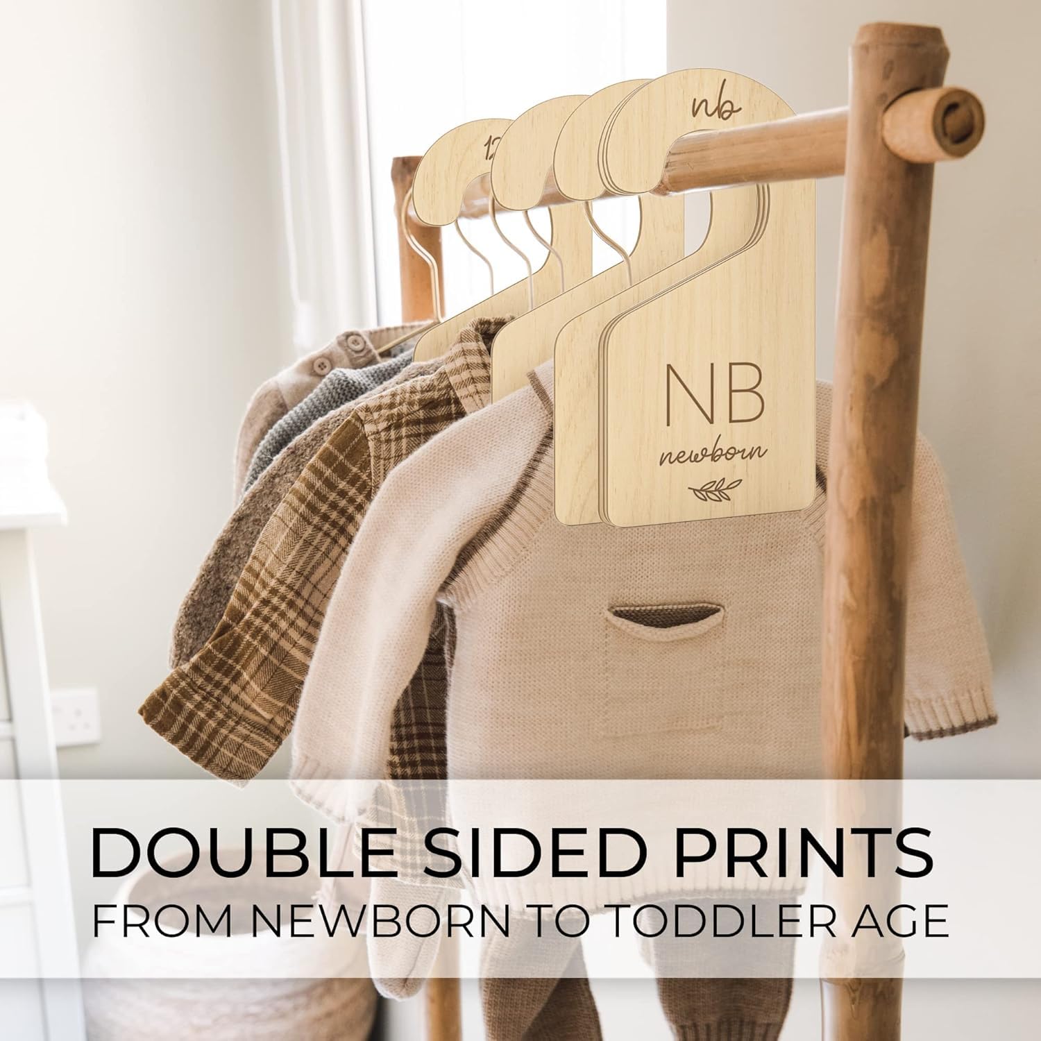 Wooden hangers with baby clothes on a wooden rack, featuring 'NB' tags.