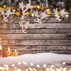 Decorative reindeer garland with Christmas lights and candles on a wooden background