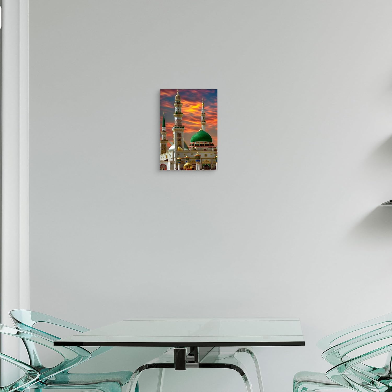 Modern glass dining table with chairs against a white wall with a framed picture of a mosque.