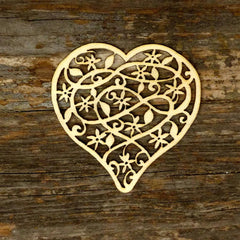 Decorative heart-shaped cutout with intricate patterns on a wooden surface