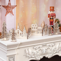 Decorative Christmas scene with trees, houses, and a nutcracker on a mantelpiece.