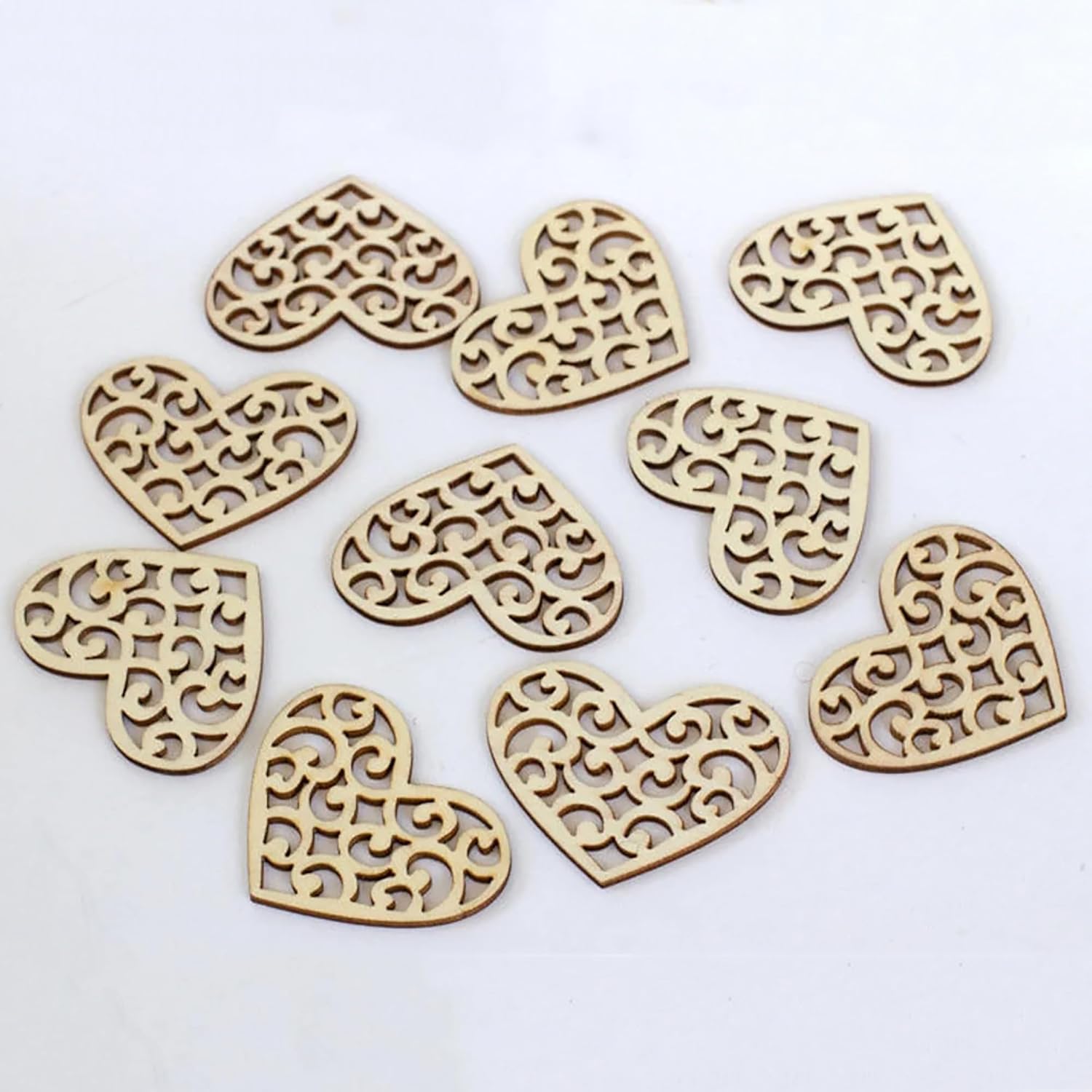 Decorative wooden heart shapes with intricate cut-out patterns on a white background