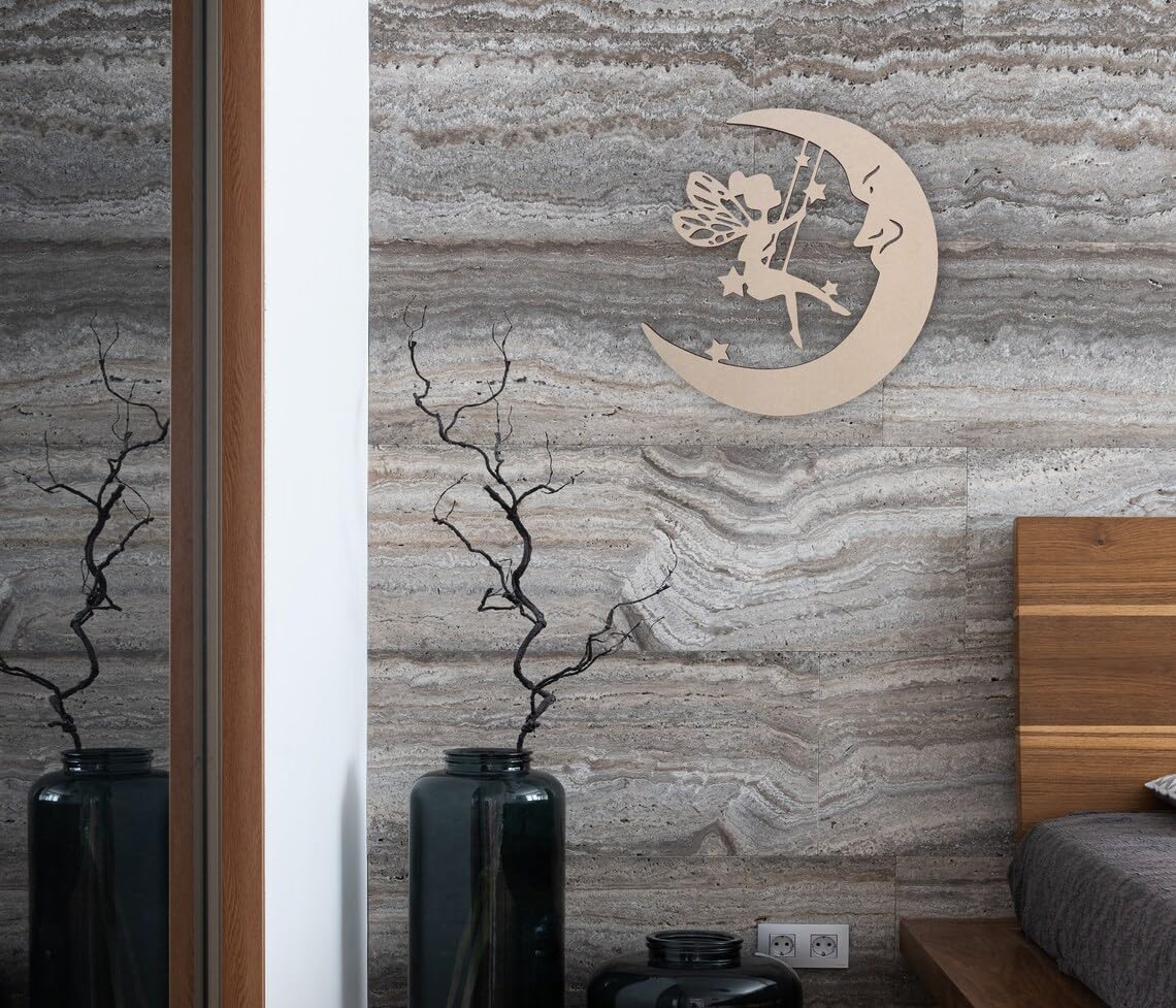 Decorative wall art of a fairy on a crescent moon against a textured wall.