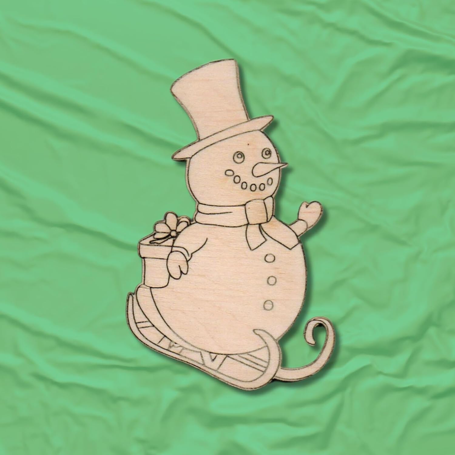 Wooden snowman decoration with a top hat on a green fabric background