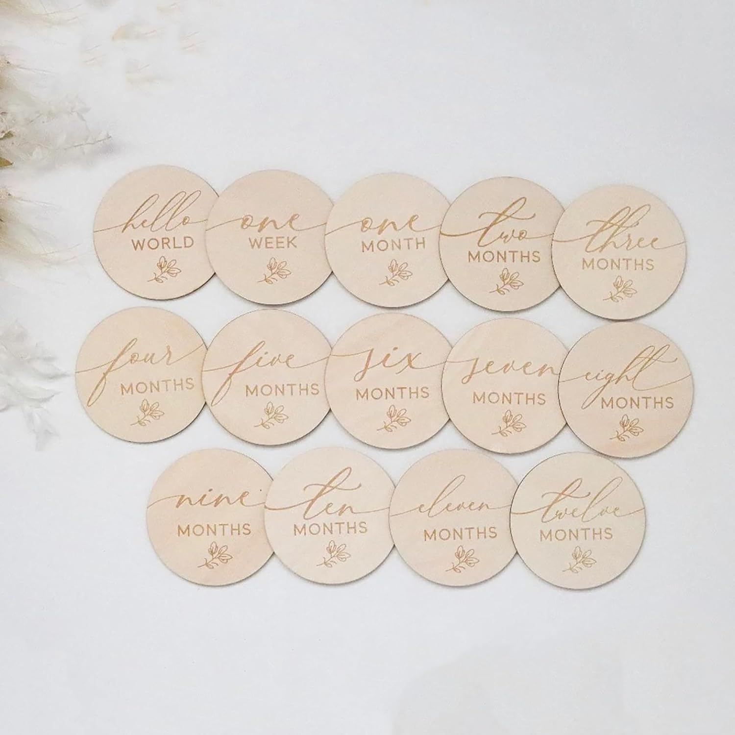 Round wooden discs with milestone text on a light background
