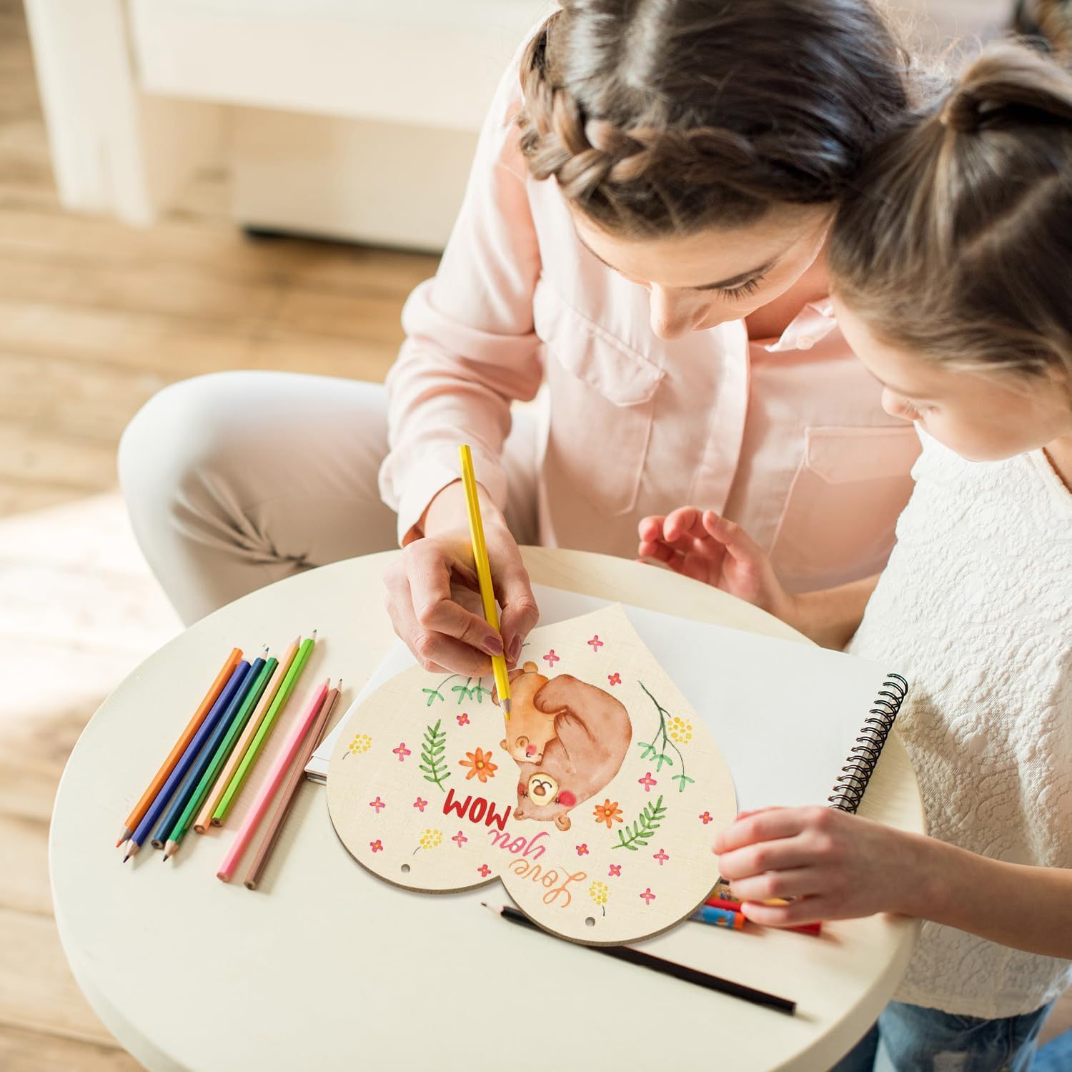 Two children drawing on a round wooden board with colorful pencils.