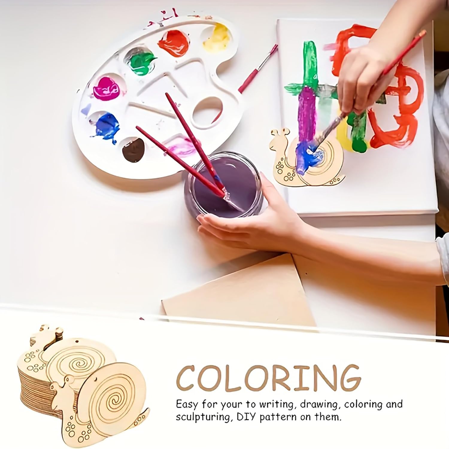 Person coloring on a wooden board with paint and brushes, surrounded by art supplies.