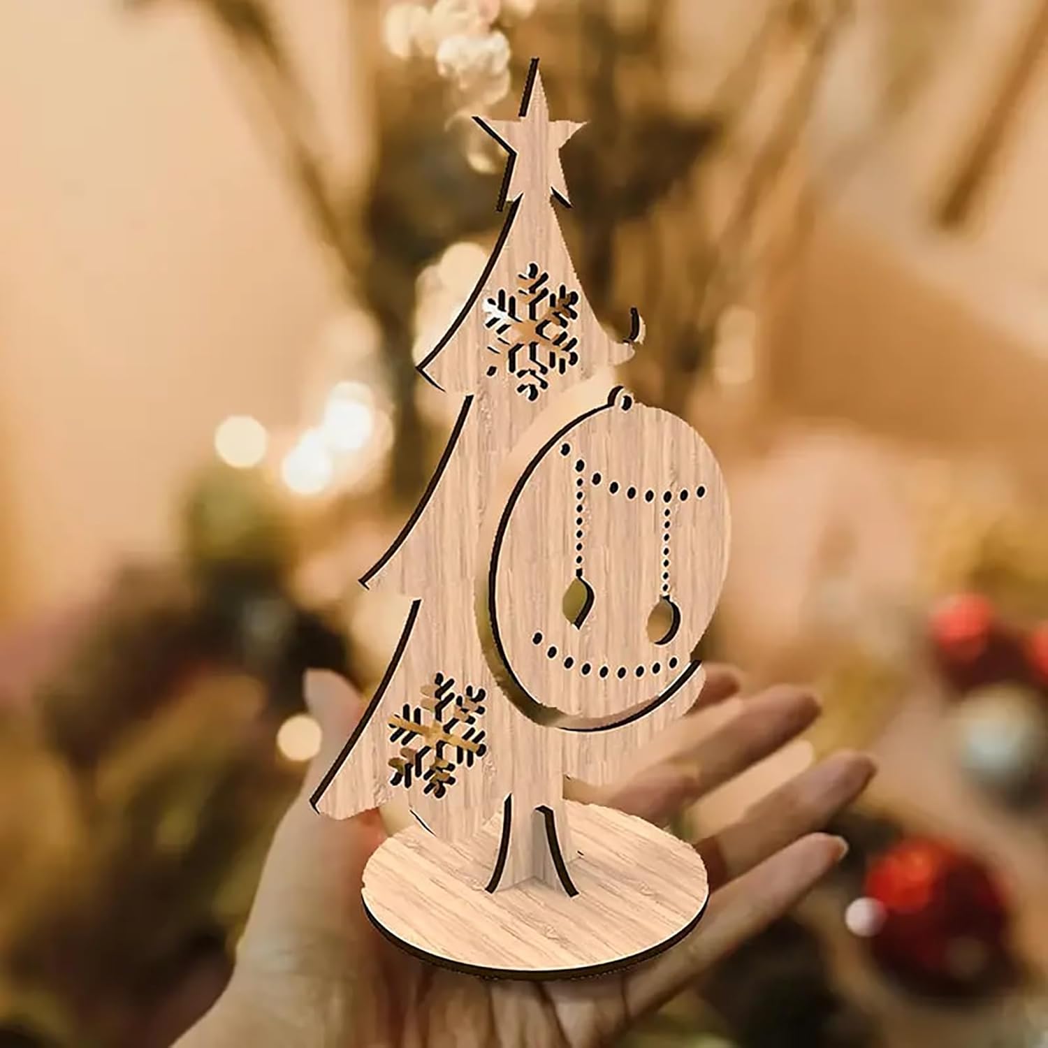 Wooden Christmas tree decoration held in a hand with blurred festive background