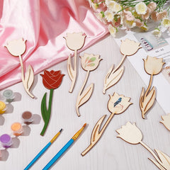 Wooden tulip shapes with paint supplies on a light surface