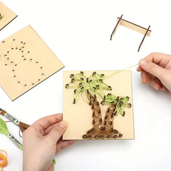 Handmade string art project on a wooden board with hands holding it.