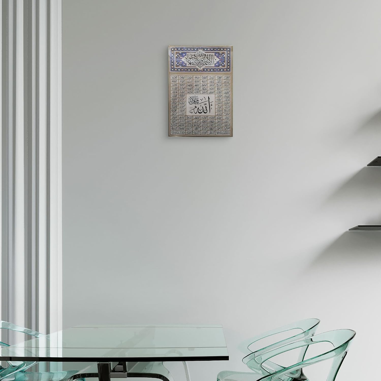 Decorative wall art with Arabic calligraphy on a white wall above a glass table.