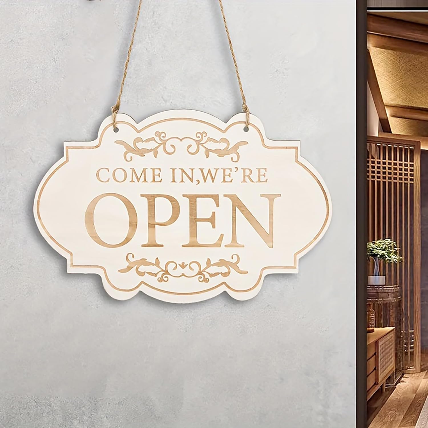 Decorative 'COME IN, WE'RE OPEN' sign on a light gray wall.