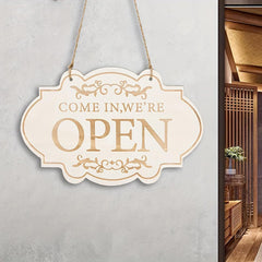 Decorative 'COME IN, WE'RE OPEN' sign on a light gray wall.