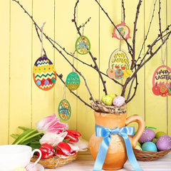 Decorative Easter setup with branches, colorful eggs, tulips, and a pitcher on a yellow background.