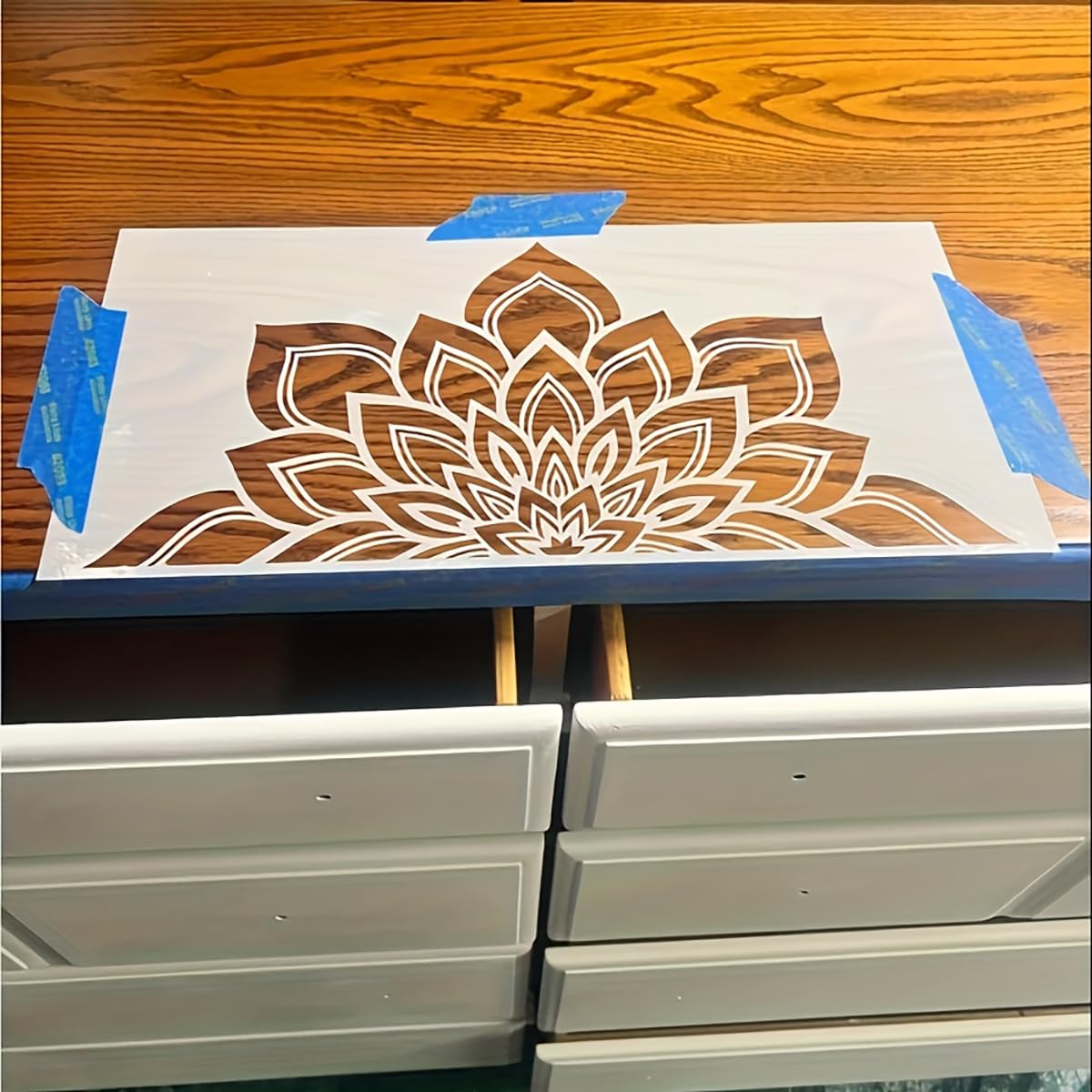 Wooden drawer set with a floral design being painted on top