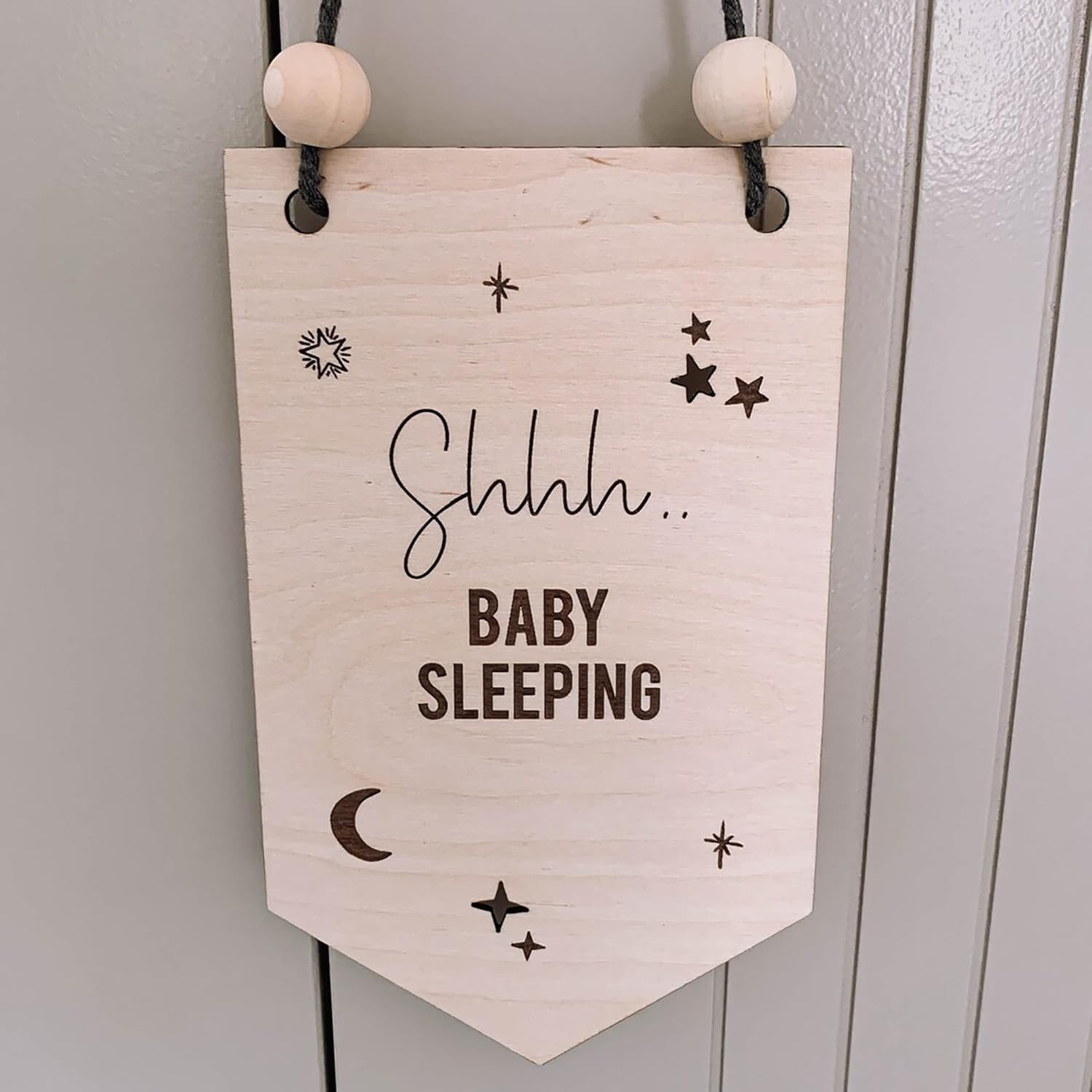 Wooden sign with 'Shhh... Baby Sleeping' text and star designs on a white background