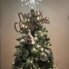Decorated Christmas tree with 'Merry Christmas' sign and lights on a plain background