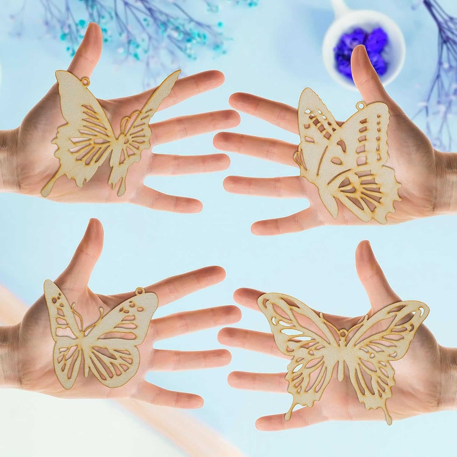 Four hands holding wooden butterfly shapes against a light blue background