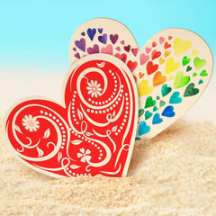 Heart-shaped decorative items on a sandy surface with a blue gradient background