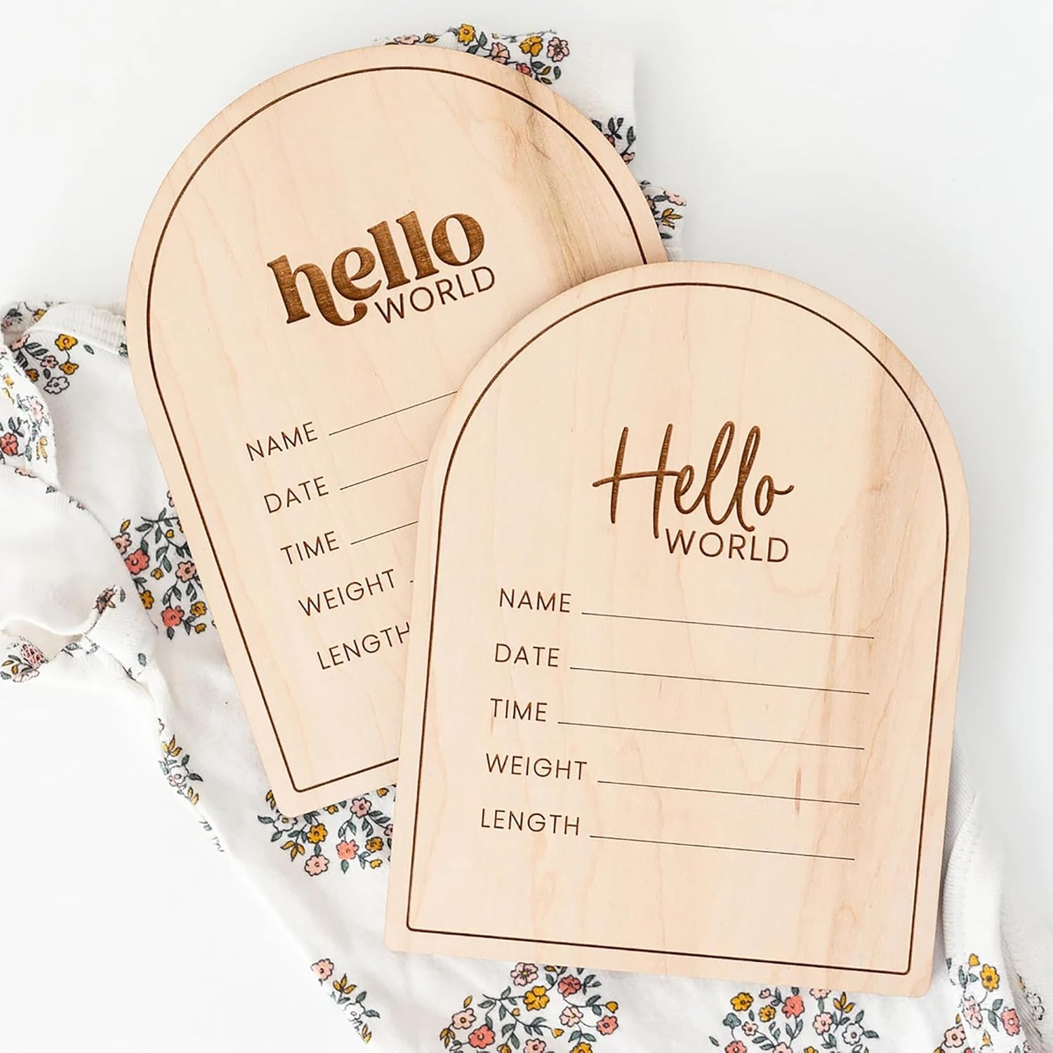 Two wooden baby登记 boards with 'hello world' text on a floral blanket.