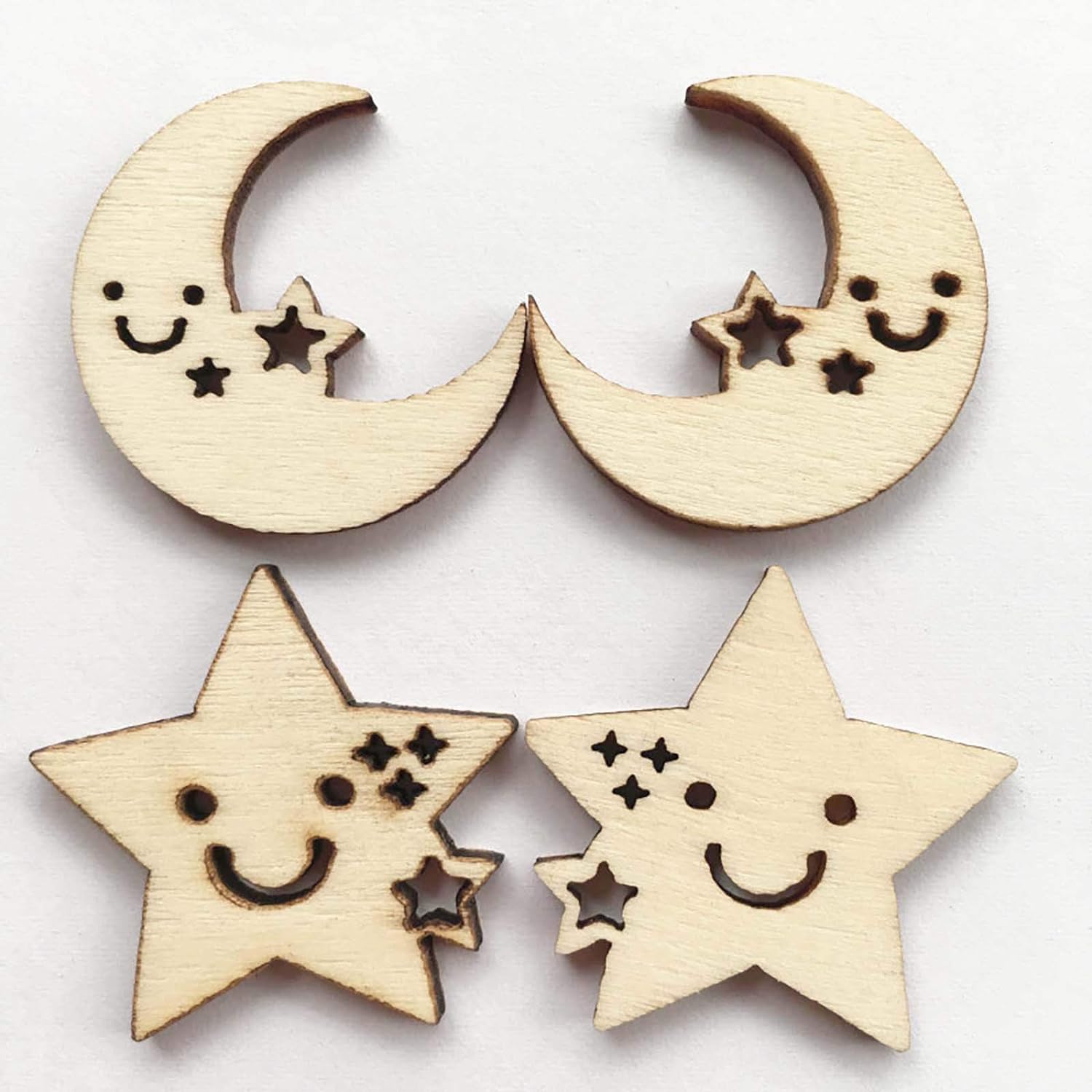 Wooden moon and star-shaped decorations with smiley faces on a white background