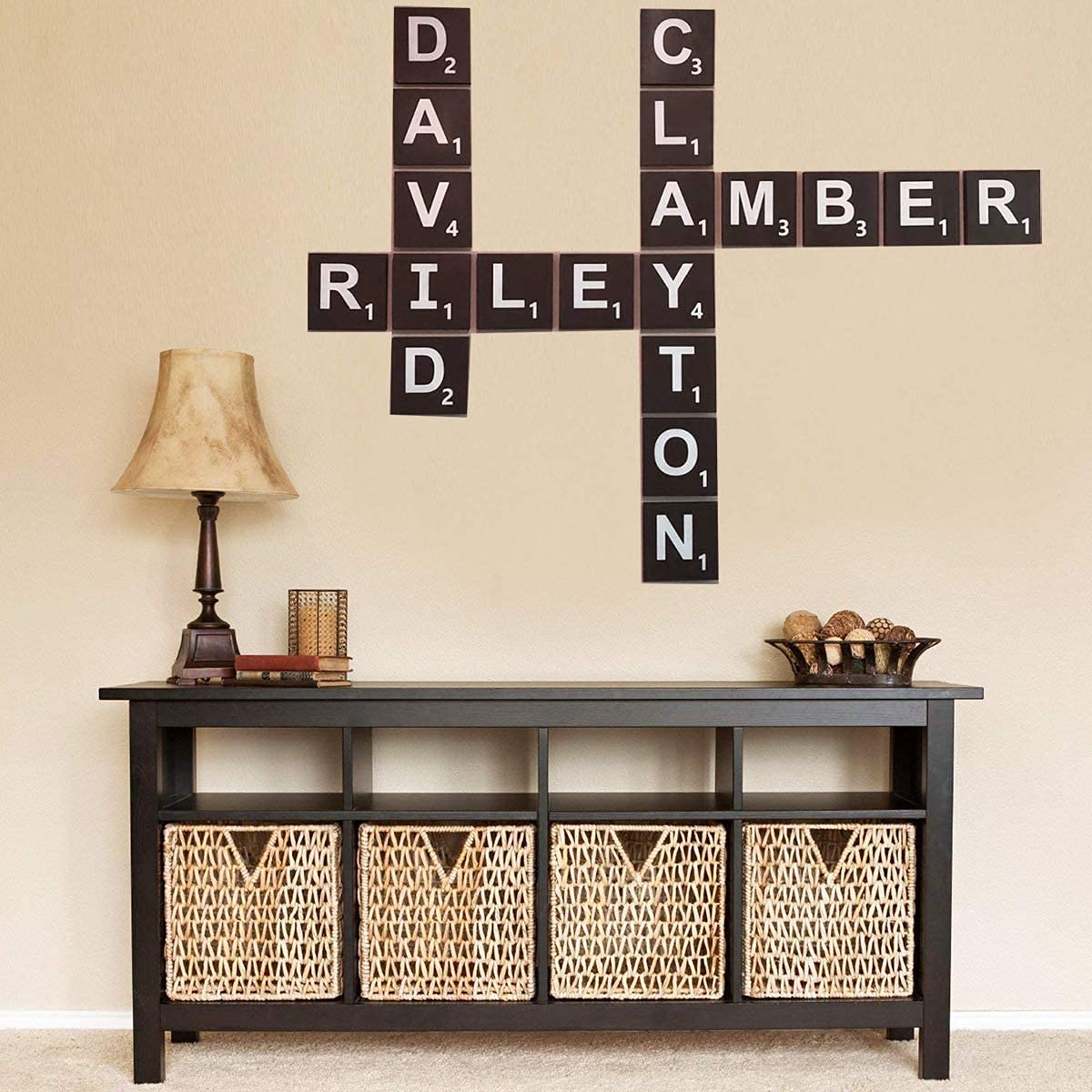 Wall with Scrabble tile wall art above a console table with wicker baskets.