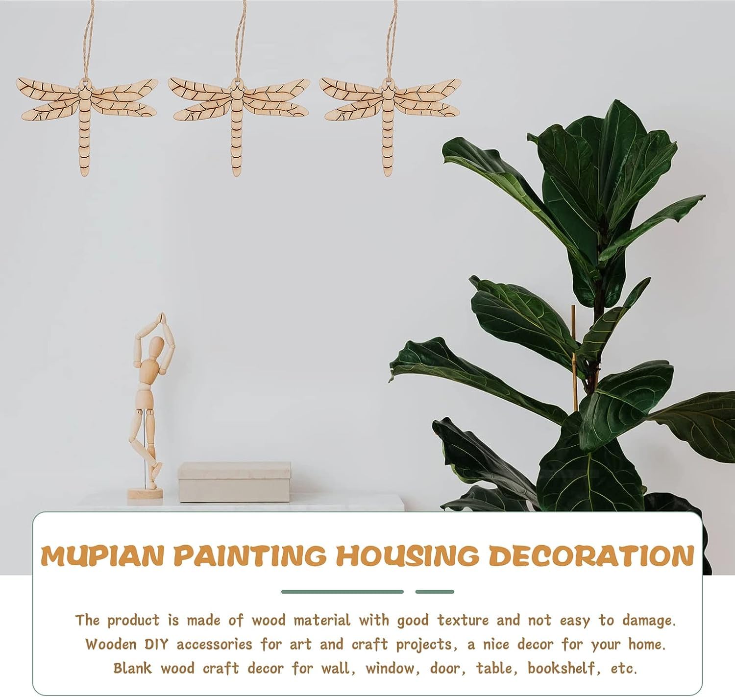Wooden dragonfly decorations, a small statue, and a plant on a white surface with text about MUPIAN PAINTING HOUSING DECORATION.