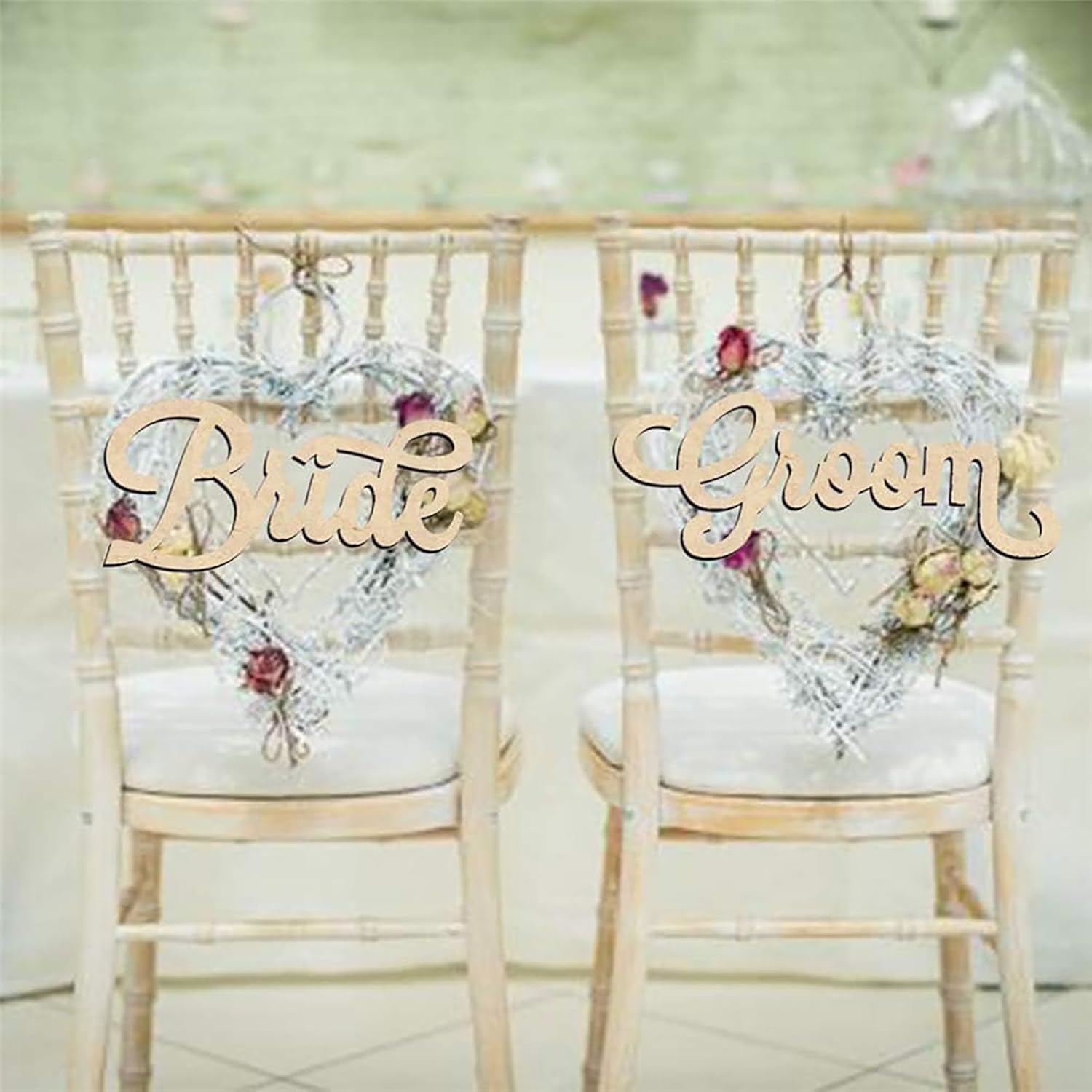 Two chairs with decorative heart-shaped signs labeled 'Bride' and 'Groom' on a light background.