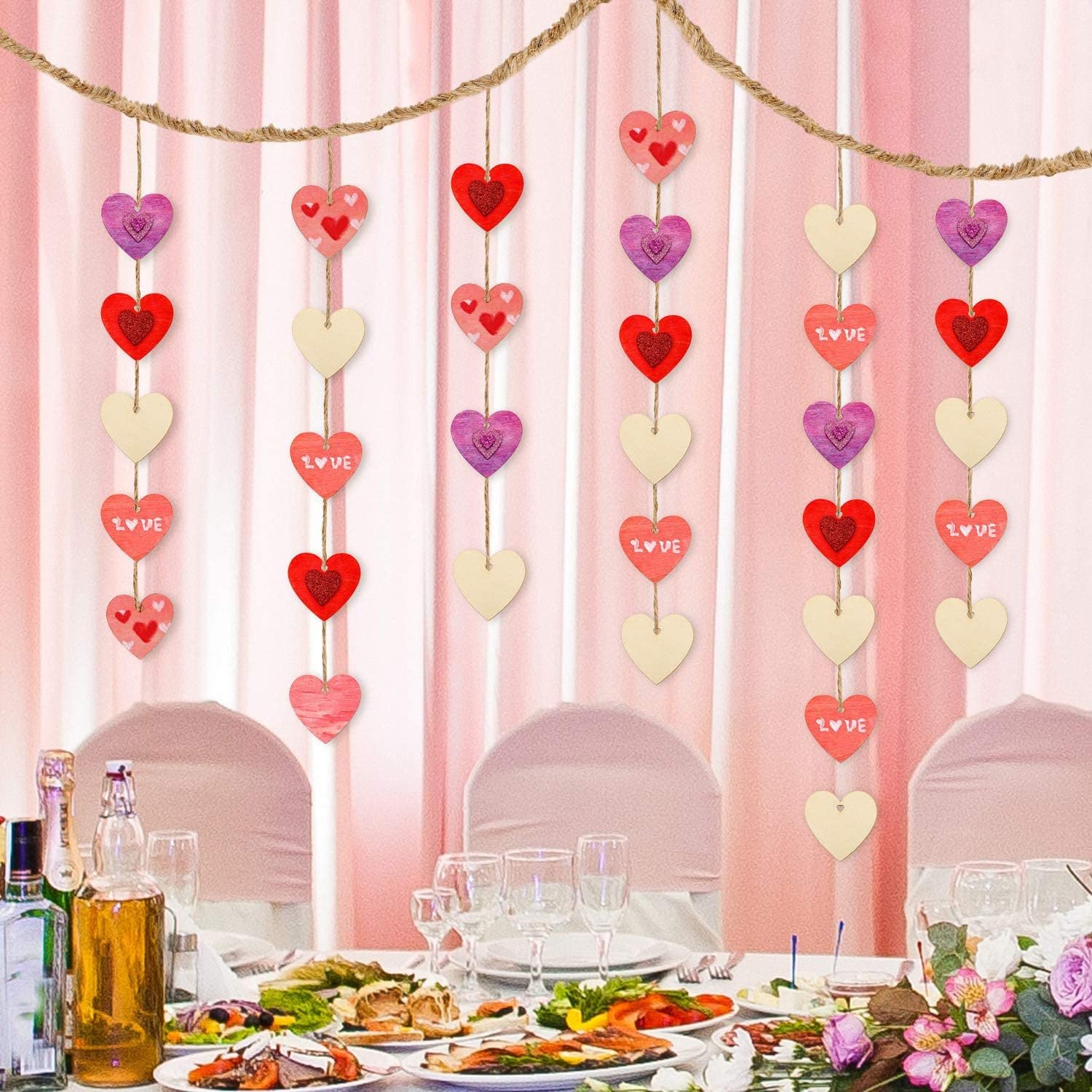 Decorative heart-shaped banner with 'LOVE' text hanging above a table set for a meal.
