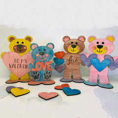 Four colorful bear figurines holding hearts with various messages on a white background
