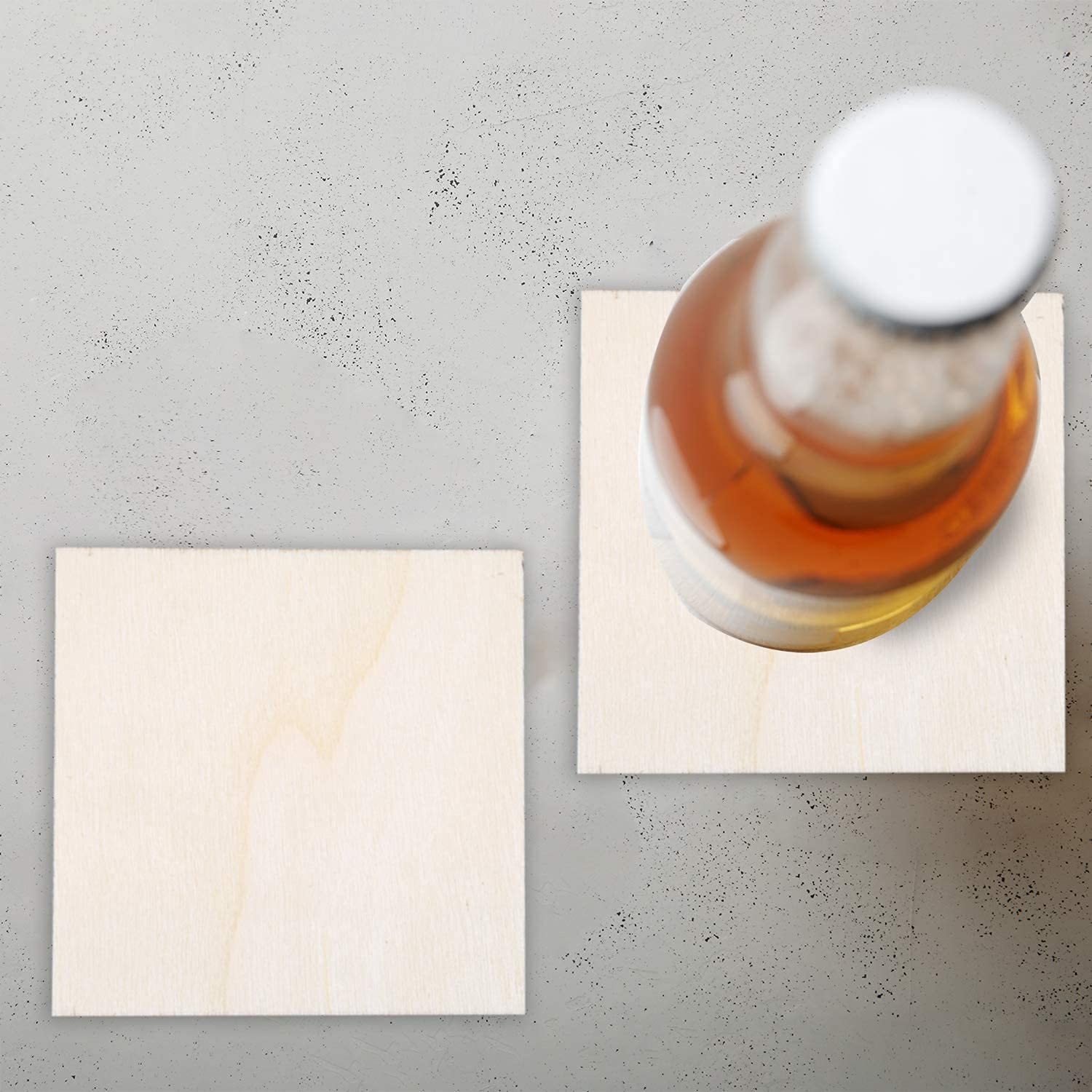 Bottle of whiskey on a coaster with a napkin on a gray surface