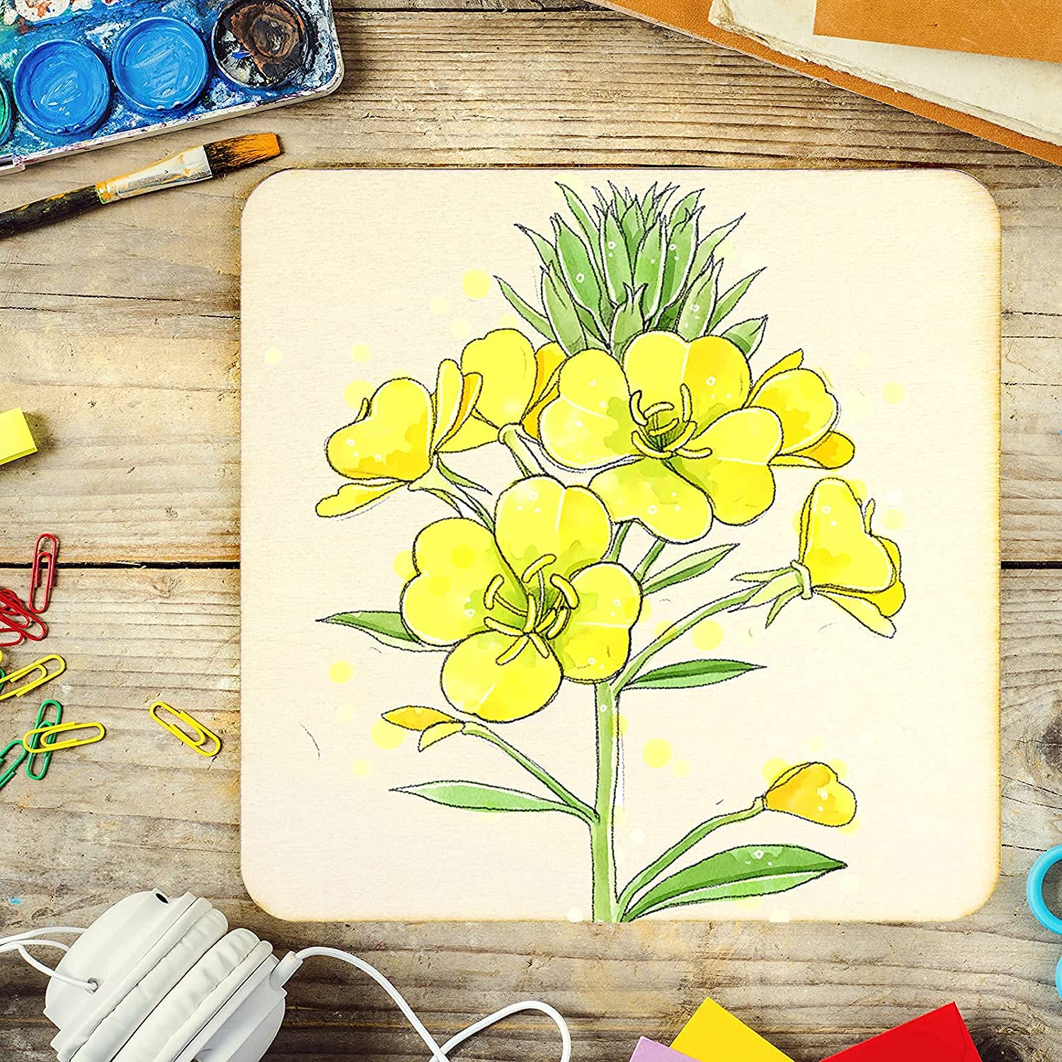 Colorful drawing of a floral design on a wooden surface with art supplies.