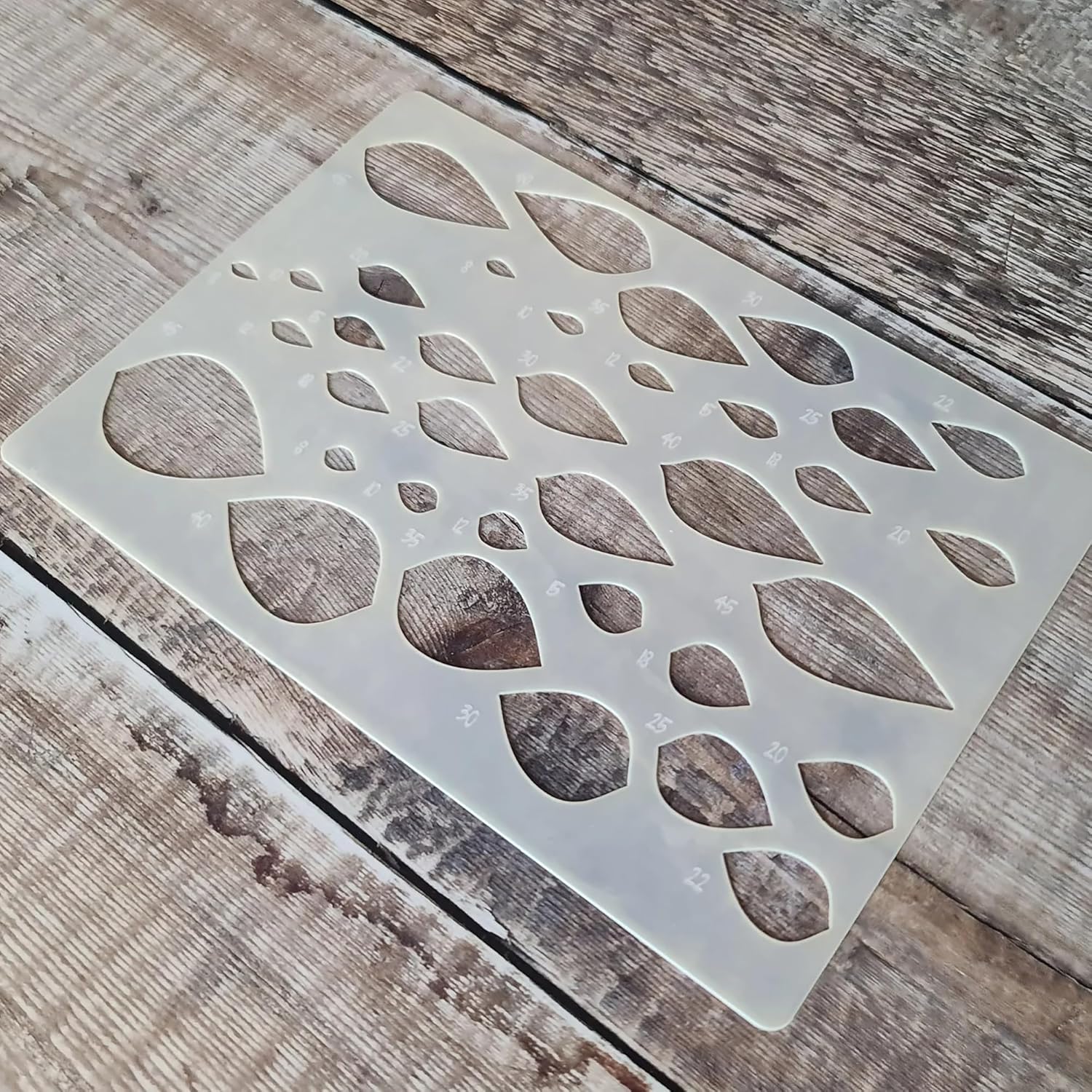 Decorative stencil with leaf pattern on a wooden surface