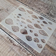 Decorative stencil with leaf pattern on a wooden surface