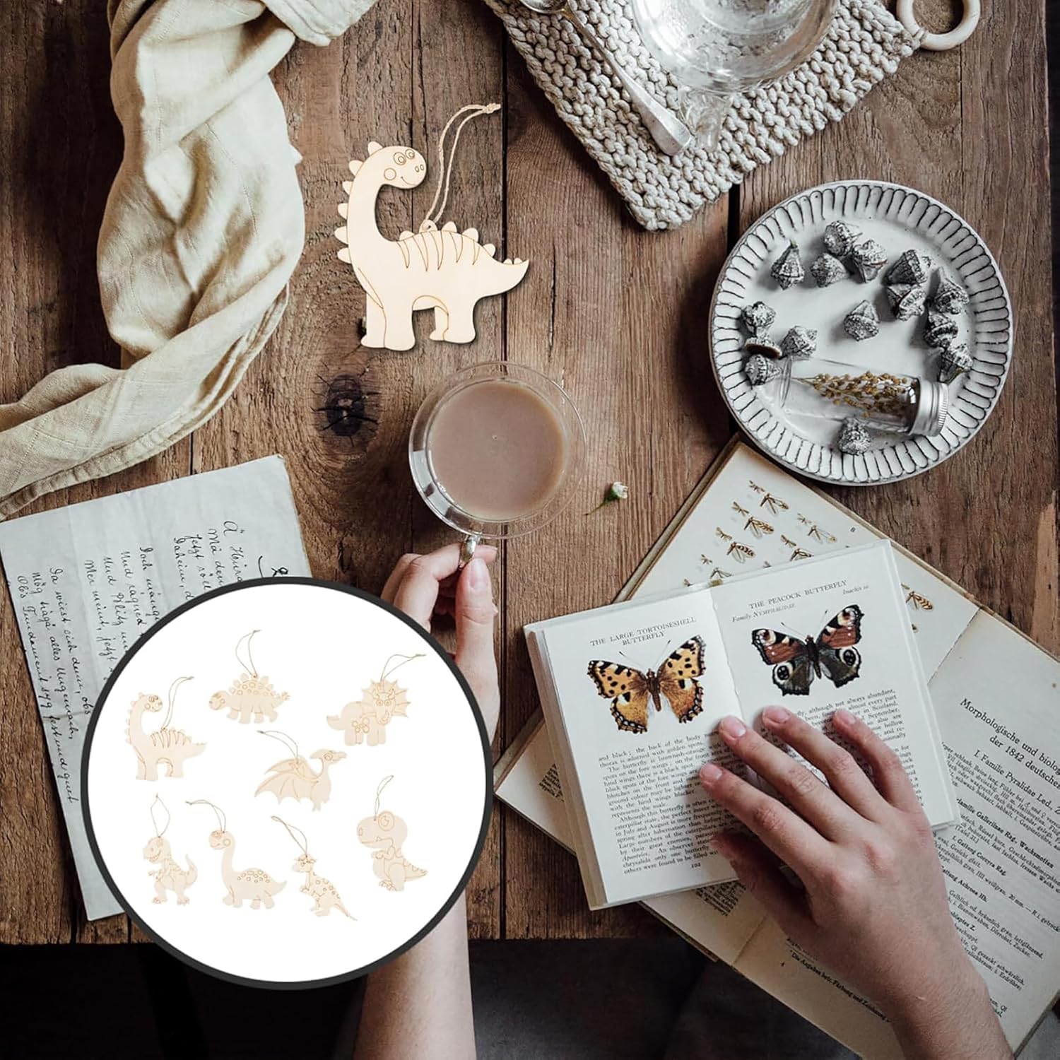 Wooden dinosaur toy, cup of coffee, and butterfly-themed book on a wooden table.